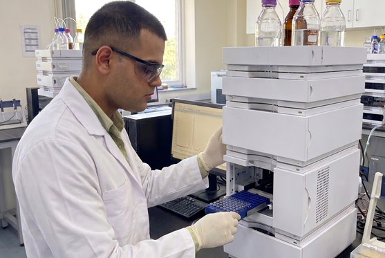 Scientist operating an HPLC system in the lab